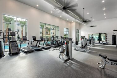 gym area with elipticals treadmills in a large open space over looking the pool area