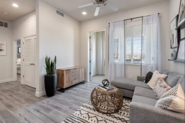 apartment living room view with couch desk stand and lights on