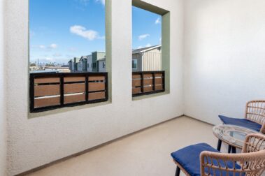 balcony with two chairs overlooking a bright sunny day