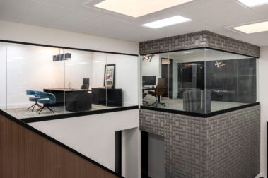 Architectural view of modern glass-enclosed executive offices situated on a raised mezzanine level, highlighting Barken's structural commercial interior capabilities.