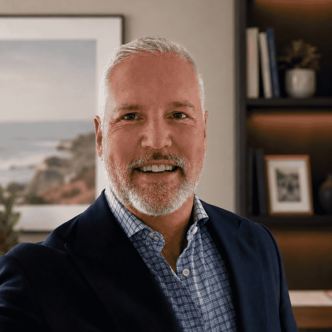 J. Kenneth Motschiedler Headshot wearing a blue blazer in an office setting